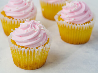 Close-up. Festive cupcakes decorated with pink fruit cream. White background. Sweet food, Birthday, holiday, card, birthday invitation, advertising, banner. Restaurant, hotel, food blog.