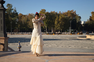 Young flamenco woman, Hispanic and brunette, with typical flamenco dance suit, with bullfighter jacket, dancing lifting her skirt. Concept of flamenco, dancer, typical Spanish dance.