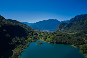 Aerial view of Lake Tenno in autumn, Trento, Italy, Europa. Turquoise lake in the mountains. Lake Garda in the background.  Mountain lake in the alps of Italy.