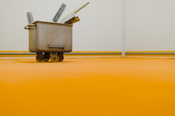 metal cart to transport meat in the meat preparation hall placed on a yellow floor
