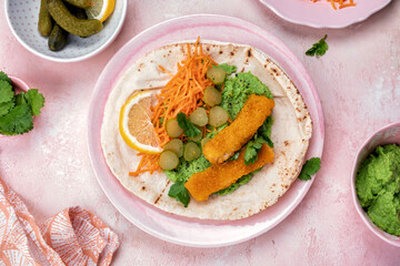 Fish fingers wraps with pea puree and vegetable in tortilla