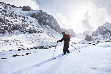 Fototapeta na wymiar Skier skiing downhill in high snowy mountains
