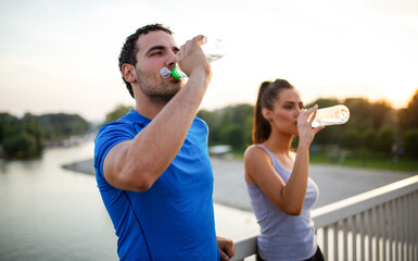 Portrait of happy fit sporty couple relaxing after a running outdoors.