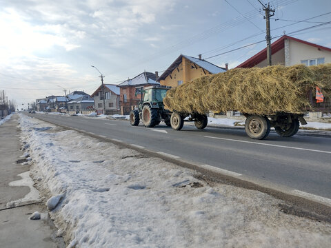 a tractor pulls a trailer loaded with hay - Maramures, Romania