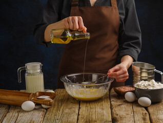 The process of making dough for pizza, pie, bread, pasta. The chef pours olive oil into the bowl of...