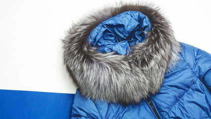 Women's blue down jacket on white background. Women's stylish autumn or winter clothes. Cozy winter...