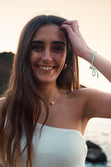 Young caucasian woman smiling wearing a white shirt at the beach.