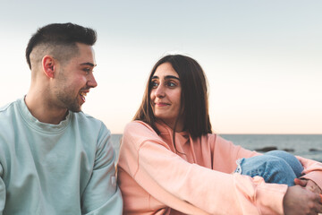 Young caucasian couple chatting at the sea side.