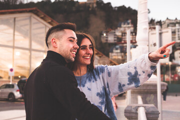 Young caucasian woman and man looking to La Kontxa bay at Donostia-San Sebastian, Basque Country.