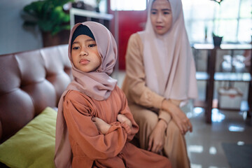 Fototapeta premium Muslim Angry asian mother sitting with little daughter