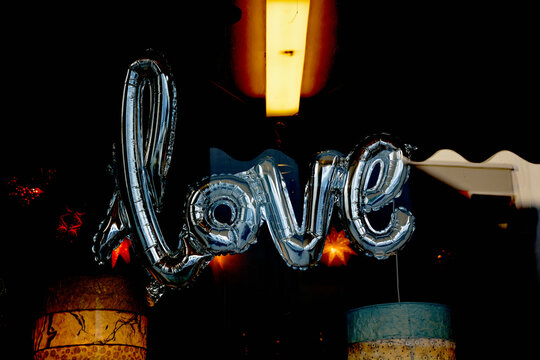 Silver colored balloon in shape of word love