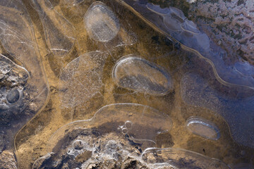 Frozen drops of water in a mud puddle