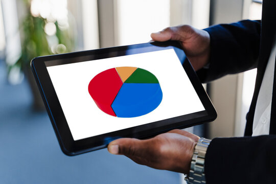Hands of businessman holding tablet PC with pie chart on screen