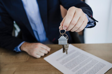Businessman holding bunch of house keys in office