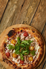 Pizza Caesar. Pizza with chicken, tomato, cheese and lettuce on wooden board. Top view. Free space for your text. Delivery food