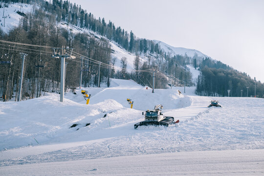 Sochi, Estosadok, Russia, 31 March 2021: Snowcat ratrack with snowplow snow grooming machine preparing ski slope piste hillalpine skiing winter resort Rosa Khutor.