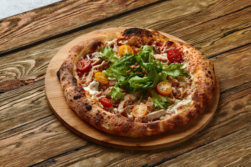 Pizza Caesar. Pizza with chicken, tomato, cheese and lettuce on wooden board. Top view. Free space for your text. Delivery food