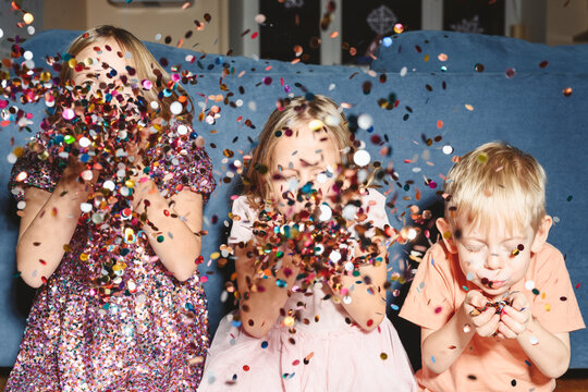 Siblings blowing confetti at home