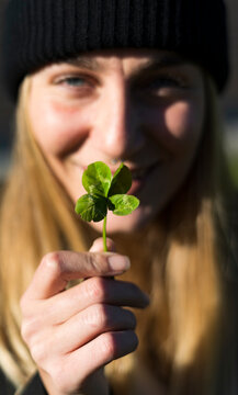 Young woman holding four-leafed clover