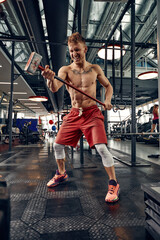 Fototapeta na wymiar Man fitness training with large and heavy tire hits hammer. Concept workout, cross strength