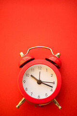 new red round clock on red table, side view
