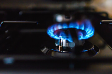 Gas burning from a kitchen gas stove at home.Gas flame with blue reflection.Close-up,selective...