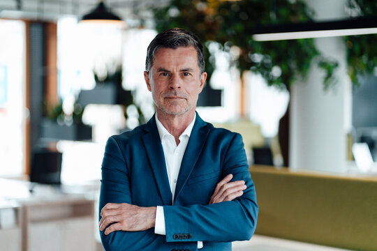 Serious businessman with arms crossed at office