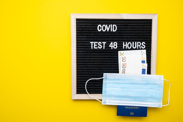 Coronavirus travel concept. Passport mask and money on a yellow background. Text covid 48 hours.