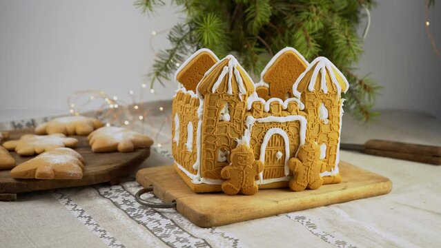 Gingerbread house Christmas homemade baking. Gingerbread Man. astle with white icing. Cookies in the shape of a Christmas tree and snowflakes on the table. Food for dessert. Winter gingerbread.