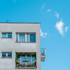 detail of tenement house or apartment building with balcony on blue sky background