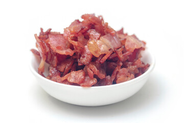 Close up of fried bacon pieces isolated white background.