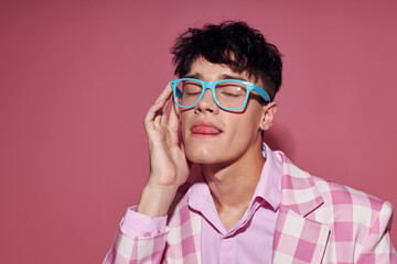 A young man fashionable glasses pink blazer posing studio pink background unaltered