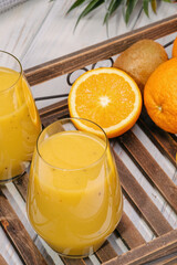 Glass of green banana, orange and kiwi healthy smoothies.