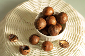 A bunch of macadamia nuts on a light background in a plate