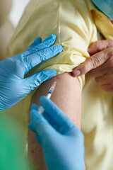 Closeup image of nurse injecting vaccine against Omicron in shoulder of male patient