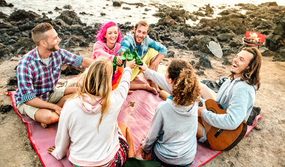 Vacationer group having fun together at beach camping party - Happy life style travel concept with young people travelers playing guitar and drinking bottled beer at summer surf camp - Contrast filter