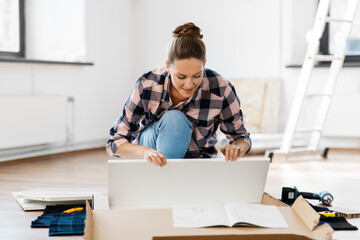 repair, improvement and furniture concept - happy smiling woman with manual assembling new locker at home