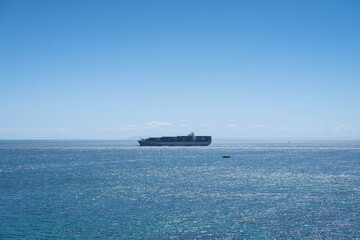 Ship Crossing the Horizon on a Sunny Day with Calm Waters 