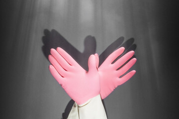 Shadow theater. Hands in rubber gloves shows the figure of a pigeon. On the dark wall, the shadow of the hands in the form of a bird