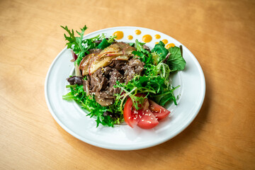 Warm salad with fried liver and onions with arugula, sesame seeds and caramelized apples. Healthy balanced lunch