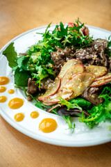 Warm salad with fried liver and onions, arugula and sesame, sprinkled with French mustard. Healthy balanced lunch