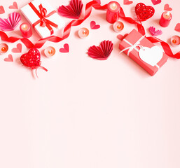 on a pink background are laid out gifts, candles, paper hearts and a red ribbon. Valentine's day frame. High quality photo