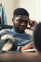 Thinking black man working on laptop computer - portrait shot. High quality photo