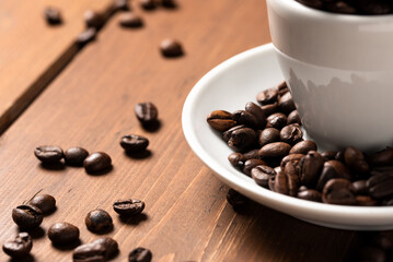 Tazzina riempita con grani di caffè tostato, espresso italiano 