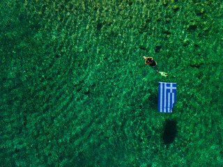 summer greece vacation woman floating in water with flag