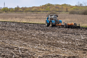 Tractor Plowing Field Tillage Agricultural land Farm Agriculture Preparing the soil for sowing. Plow Machine Equipment Working Village Season