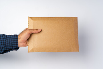 Male hand holding parcel post against white background