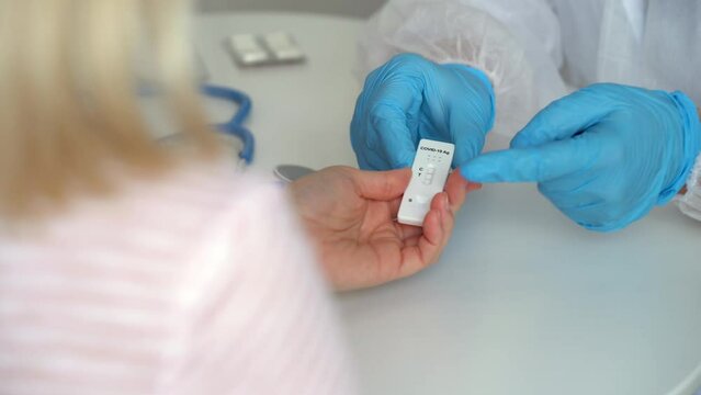 Doctors hands give rapid antigen test for covid-19 and pills to patient in clinic. Medical preparations for coronavirus. Quick swab method to SARS-CoV-2. PCR