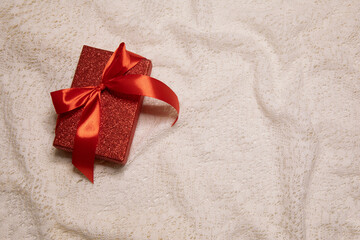 Gift box with red bow with ribbon white lace background. Valentine day image with copy space
