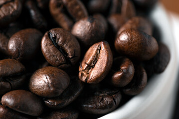 Tazzina riempita con grani di caffè tostato, espresso italiano 